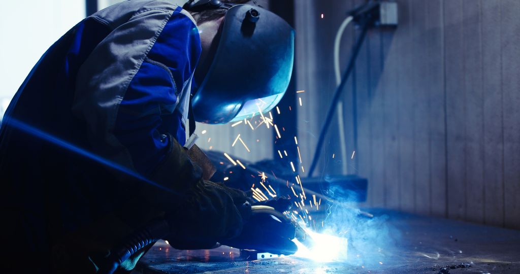 Industrial Worker at metal factory welding closeup